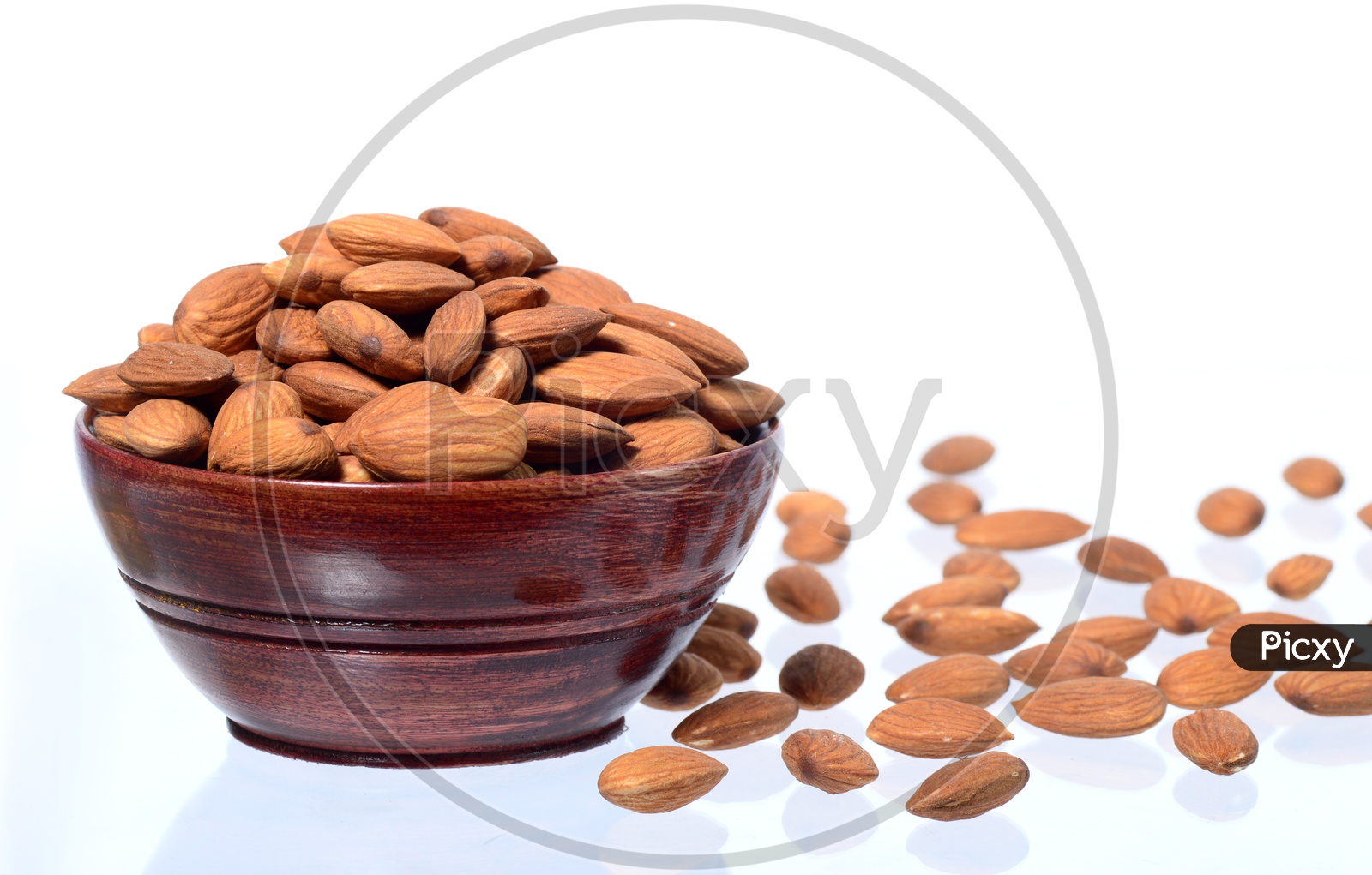 Almonds Or Badam Nuts In a Wooden  Bowl With a Heap On an Isolated White background