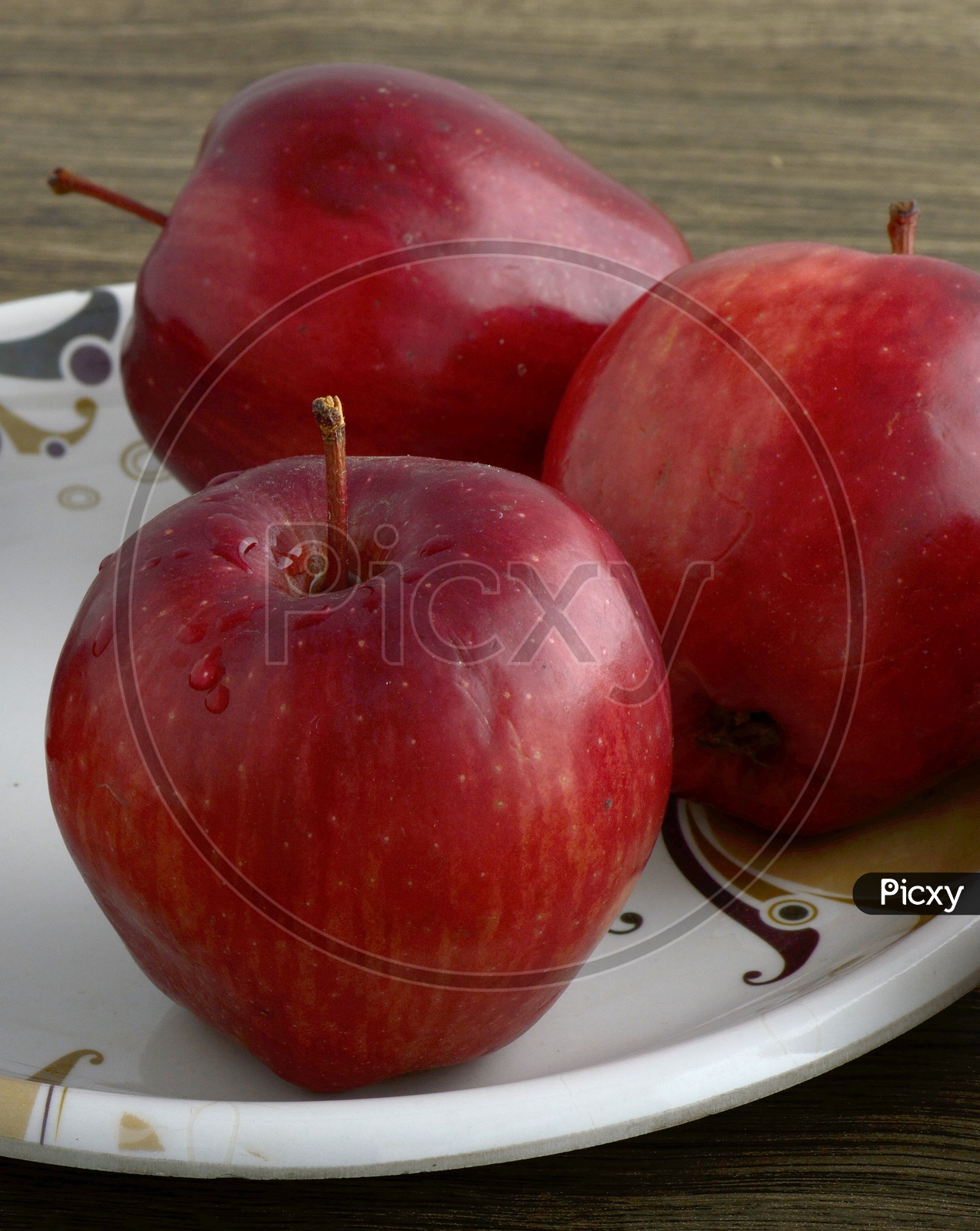 Ripen Red Apples  On a  Plate Over an Isolated Wooden  Background
