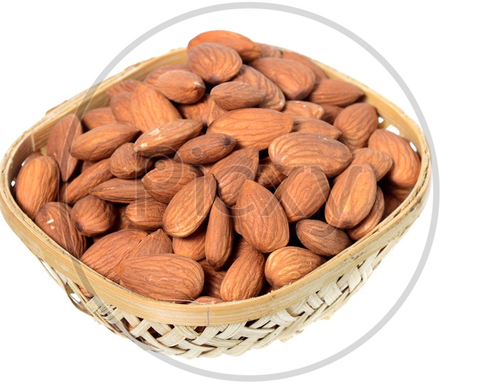 Almonds Or Badam On a Wooden Weaved Bowl  On An Isolated White Background