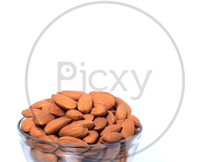 Almonds Or Badam Nuts Heap In a Glass Bowl On an Isolated White Background