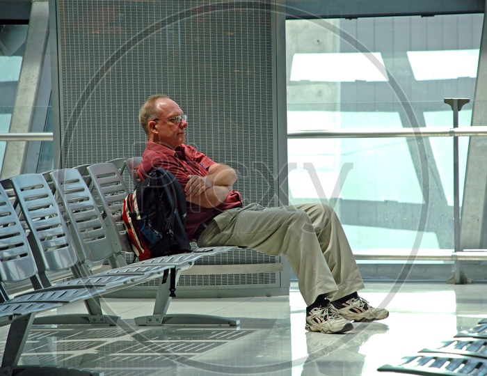 A  Tired Man  Sitting  on a Chair And Sleeping in airport
