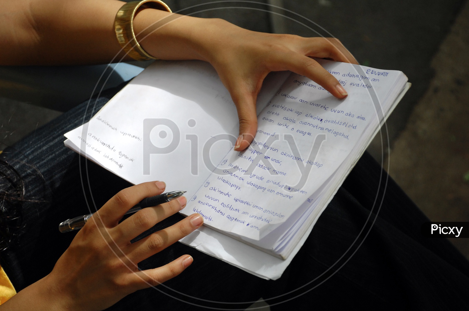 A girl writing notes with a pen