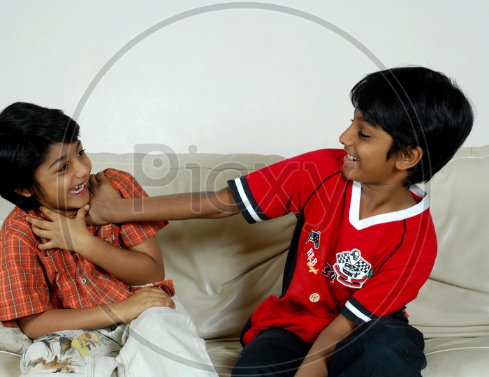 Two boys playing on the couch