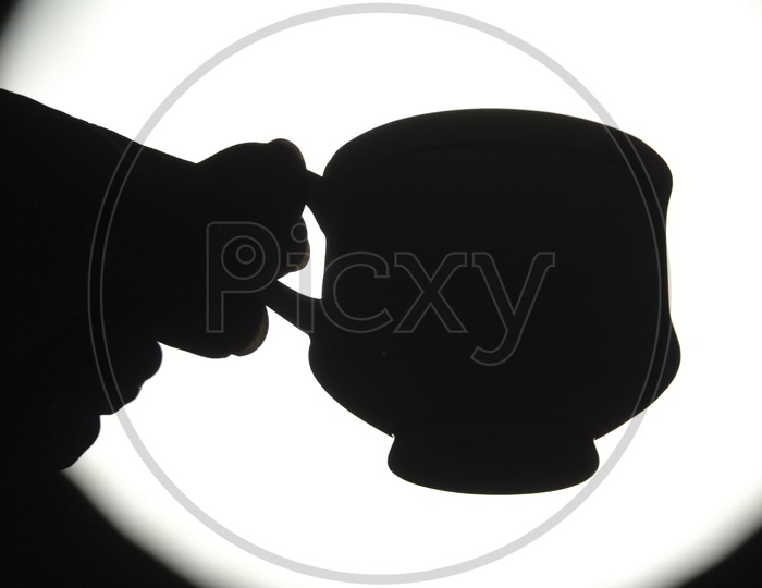 Silhouette of a cup in the hand