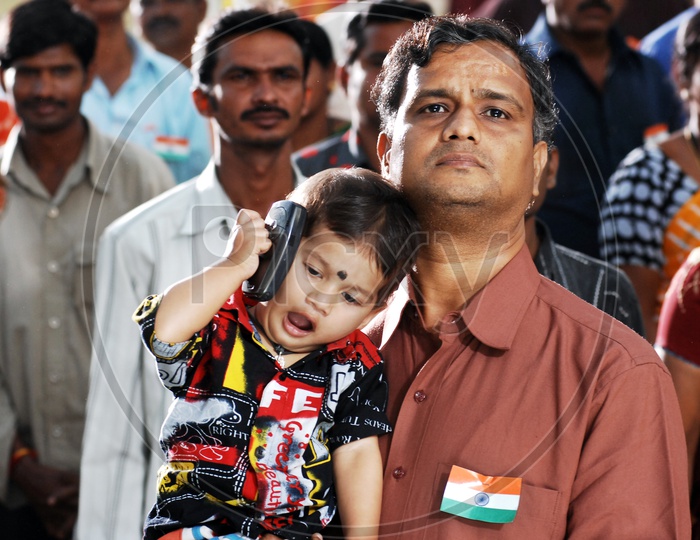 Father carrying his child during national anthem