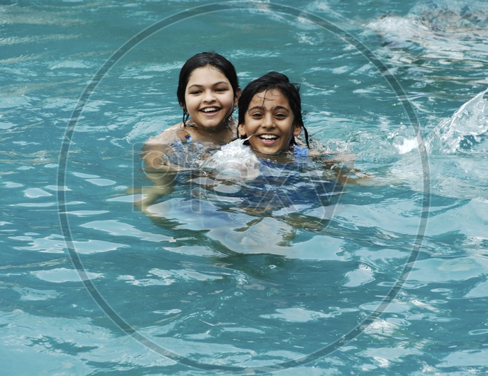 Two girls playing in a swimming pool