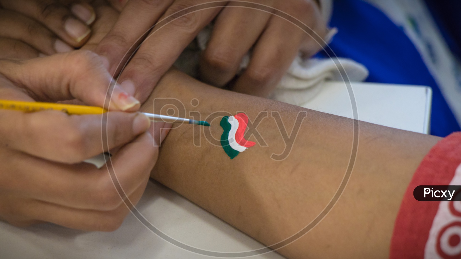 Painting an Indian Flag on arm on Independence Day celebration