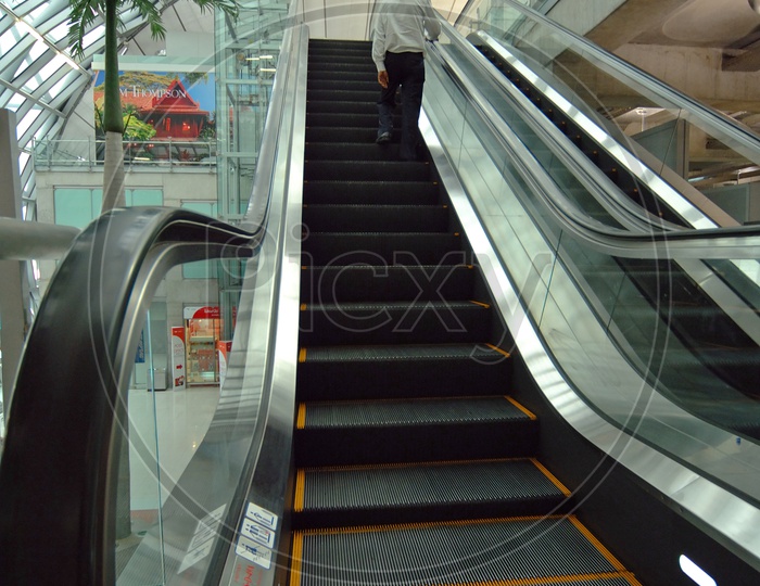 A Man Using Escalator  Stair Case in a Mall