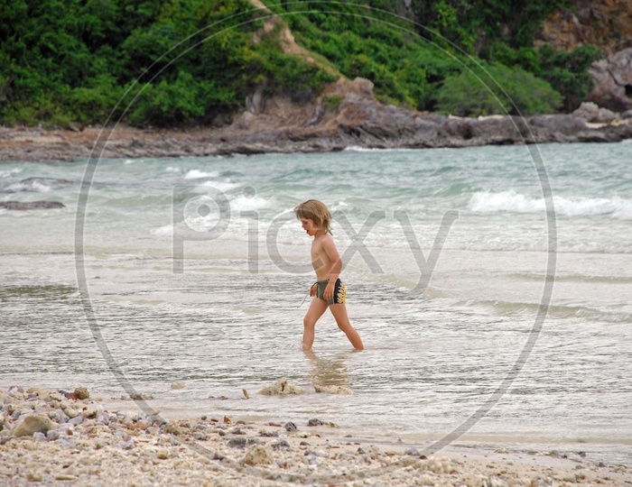 A Young Little Boy In Beach Waters