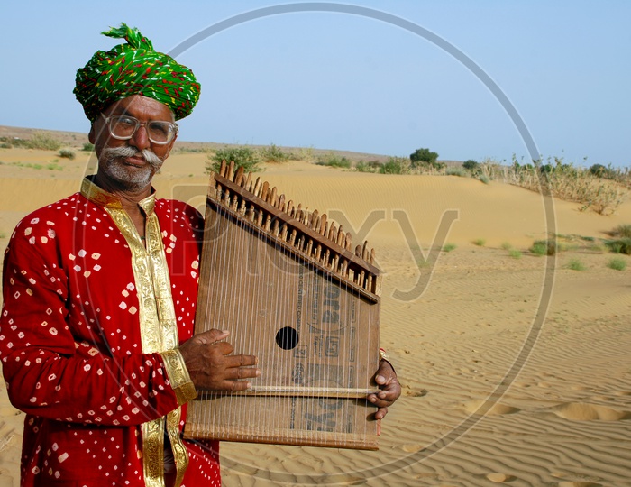Rajasthani Man playing a musical instrument in the desert