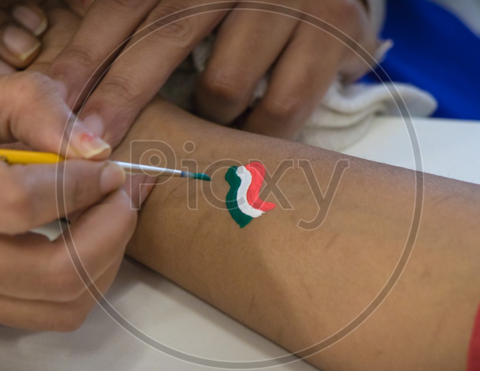 Painting an Indian Flag on arm on Independence Day celebration