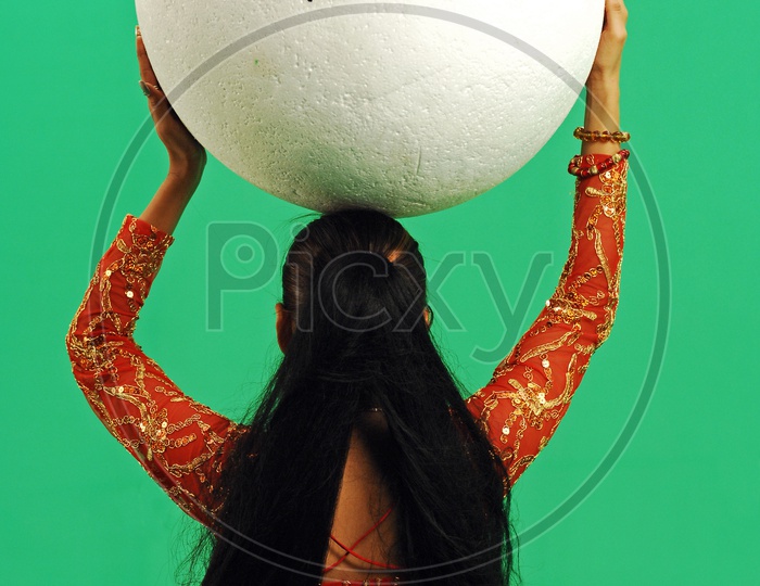 An Indian woman holding the ball