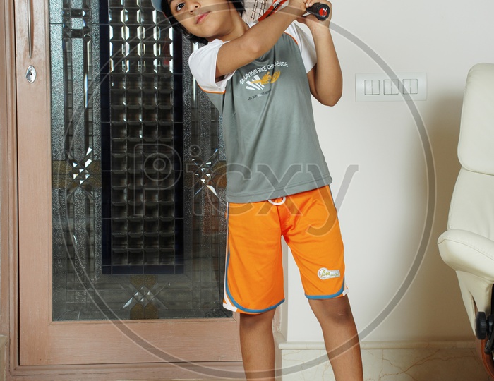 Indian boy with sportswear holding a tennis racket