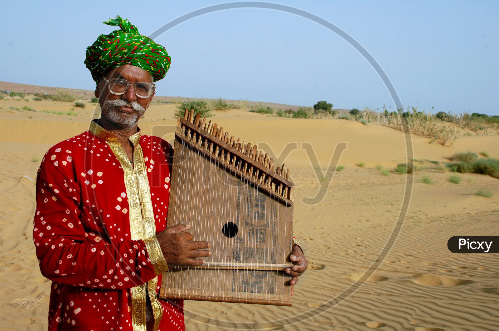 Rajasthani Man playing a musical instrument in the desert