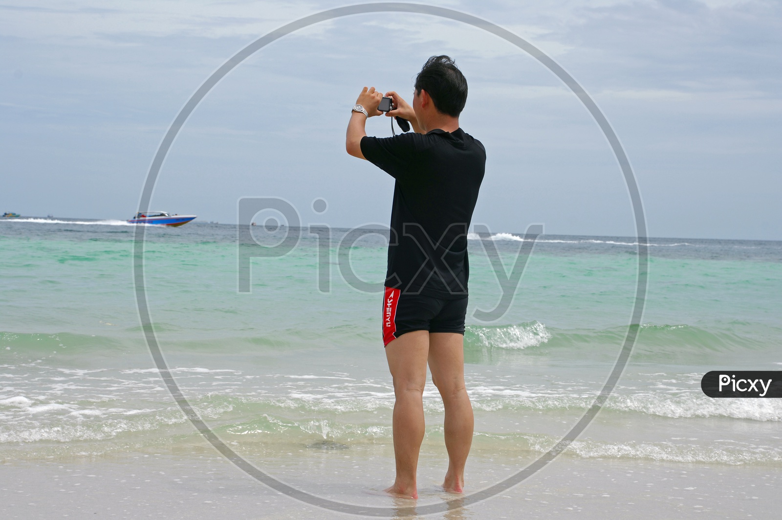 A Man Taking Picture Of Speed Boats In Sea