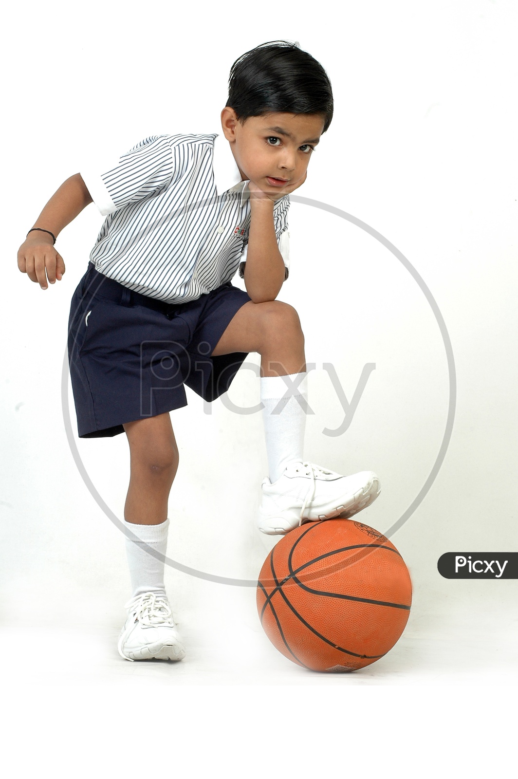 Indian boy wearing school uniform with basket ball