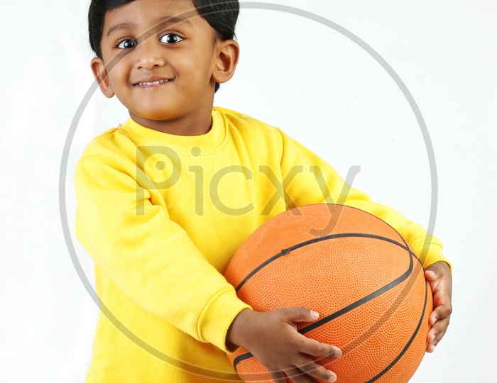 Indian boy wearing yellow t-shirt with basketball