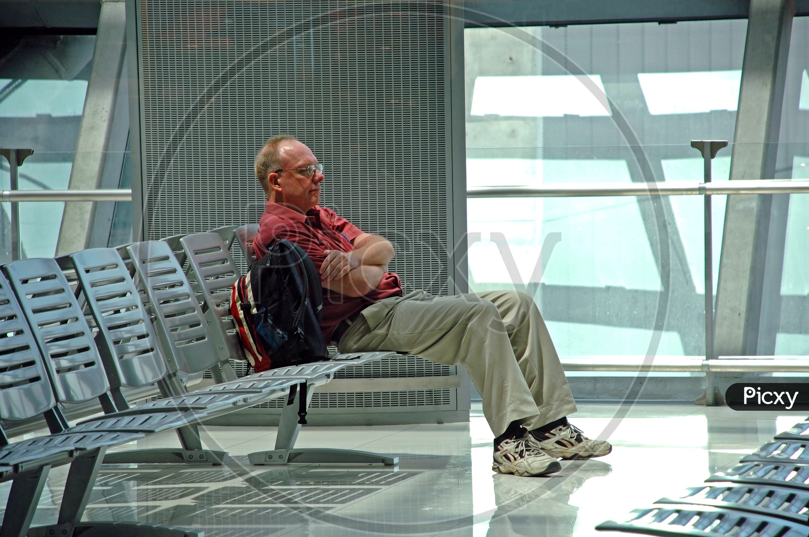 A  Tired Man  Sitting  on a Chair And Sleeping in airport