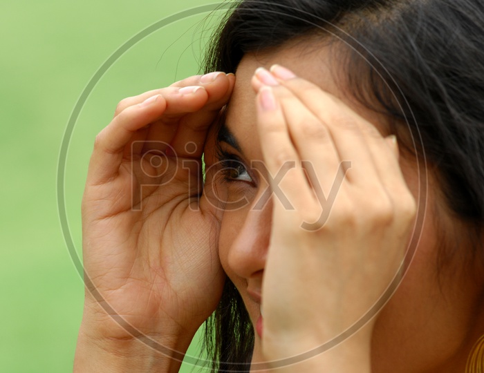 Indian woman with her hands covering the face