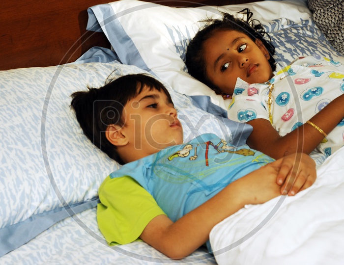 Two kids sleeping in bed
