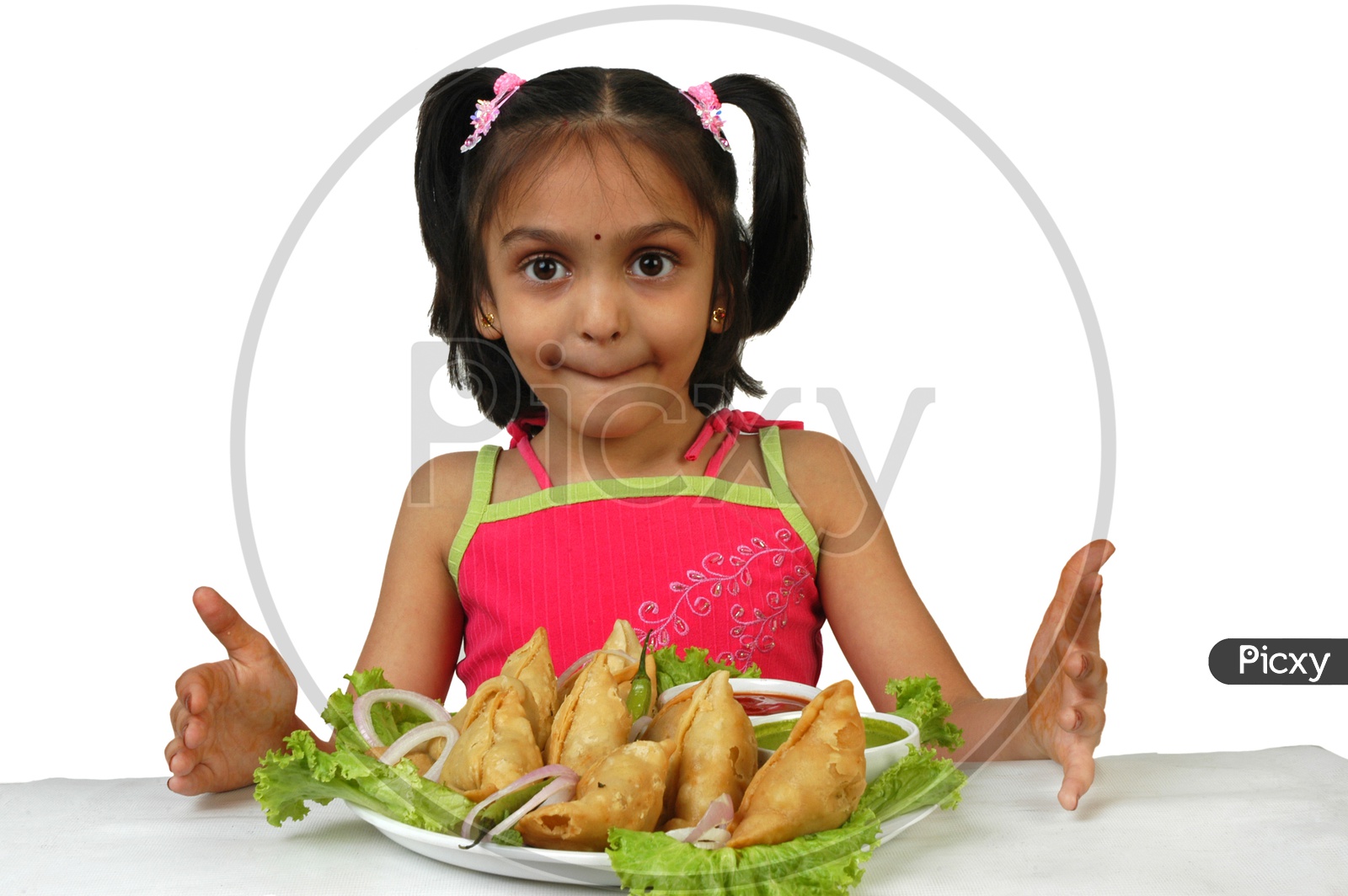 Indian little girl with samosas served in a plate