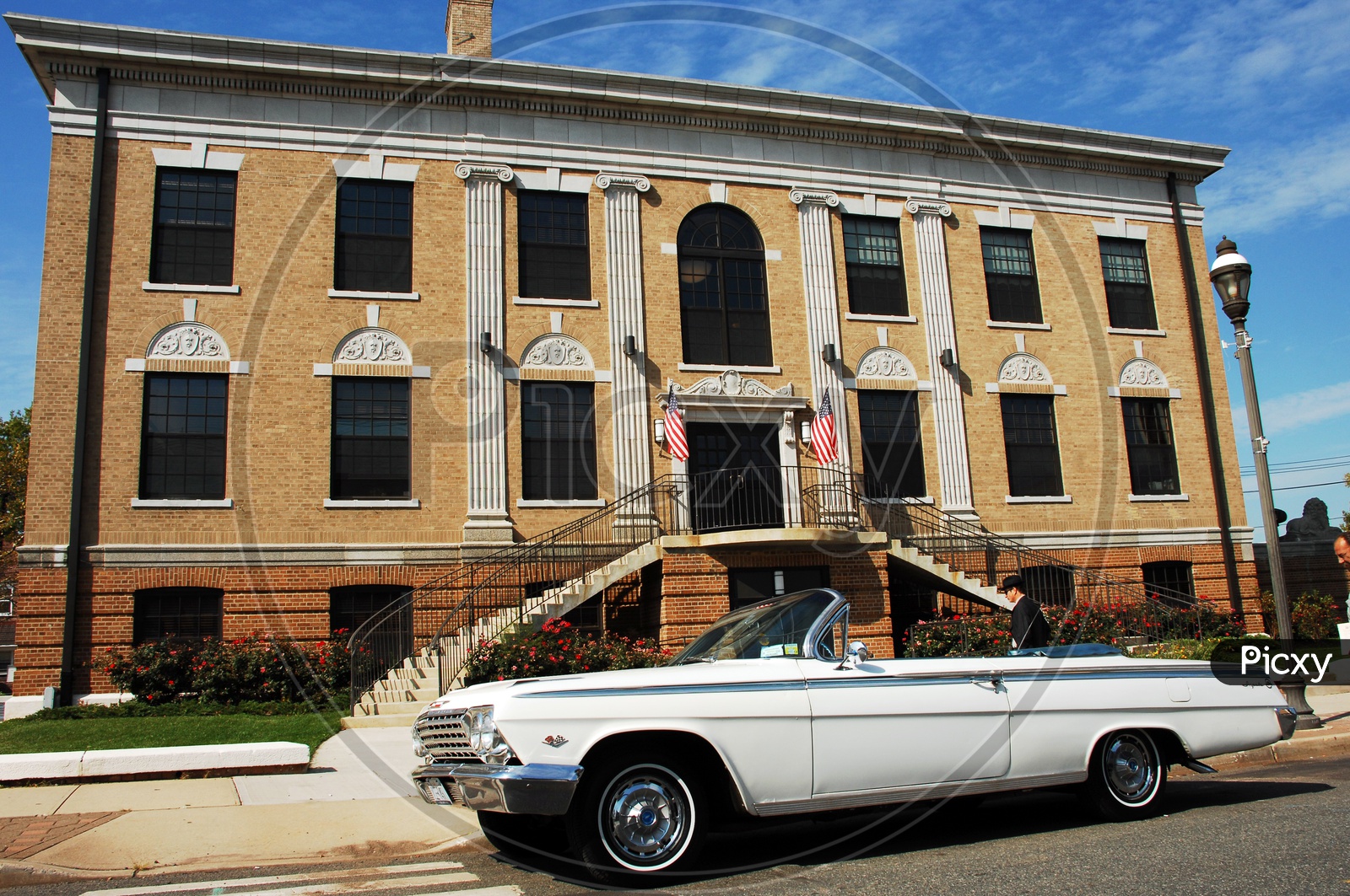 Chevrolet Impala classic topless white car besides a building