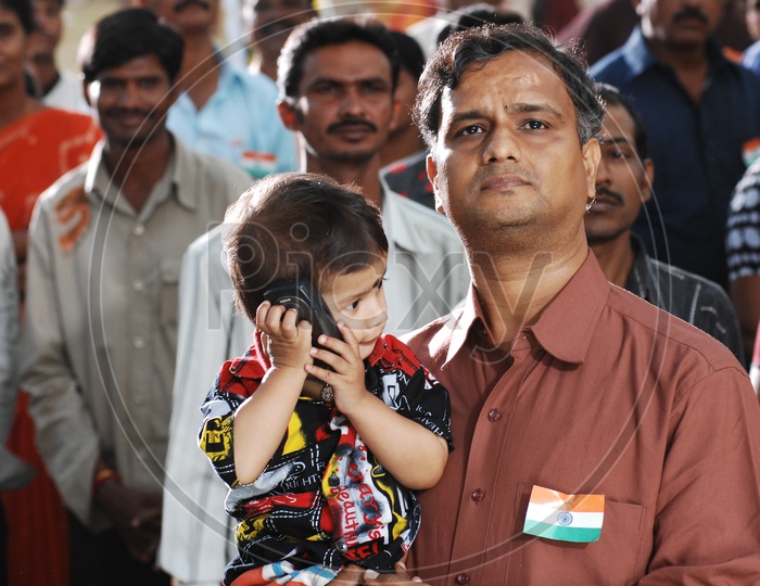 Father carrying his child during National Anthem