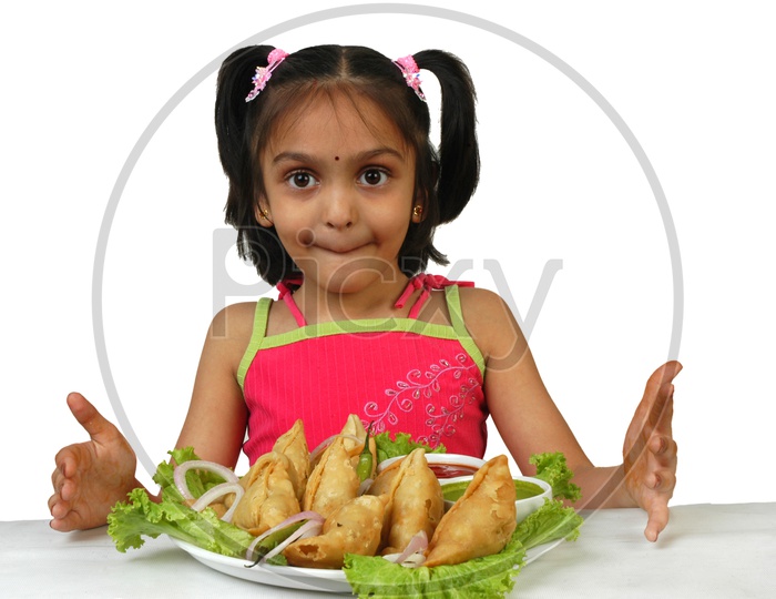 Indian little girl with samosas served in a plate