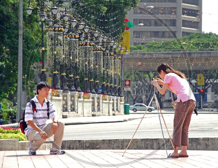 A Young Woman Taking Pictures With The Help of Tripod