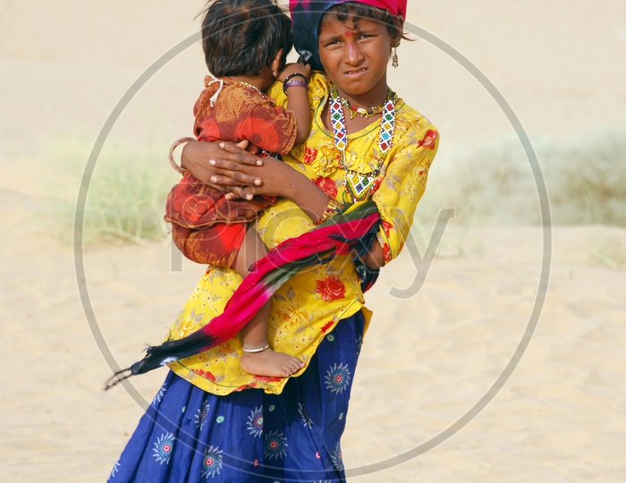 A local girl child carrying a little girl
