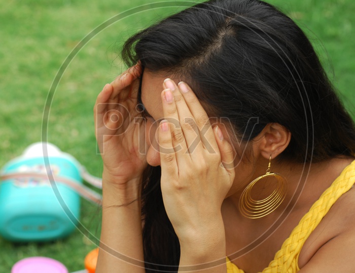 Indian woman with her hands covering the face