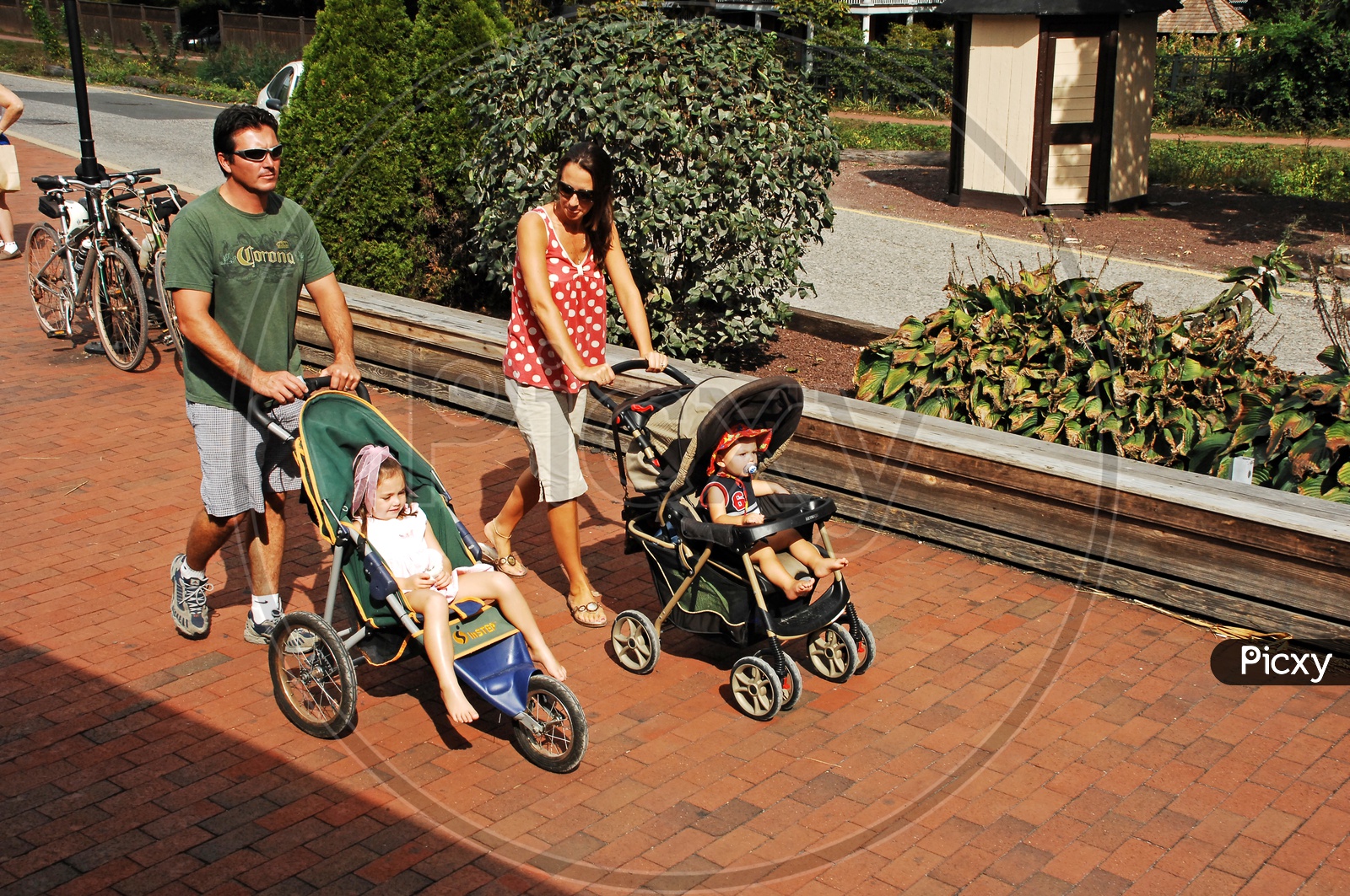 Parents taking their toddlers for a stroll in baby carriage
