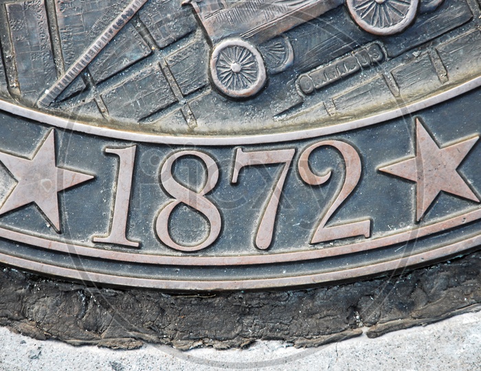 Number '1872' embossed on a metal surface
