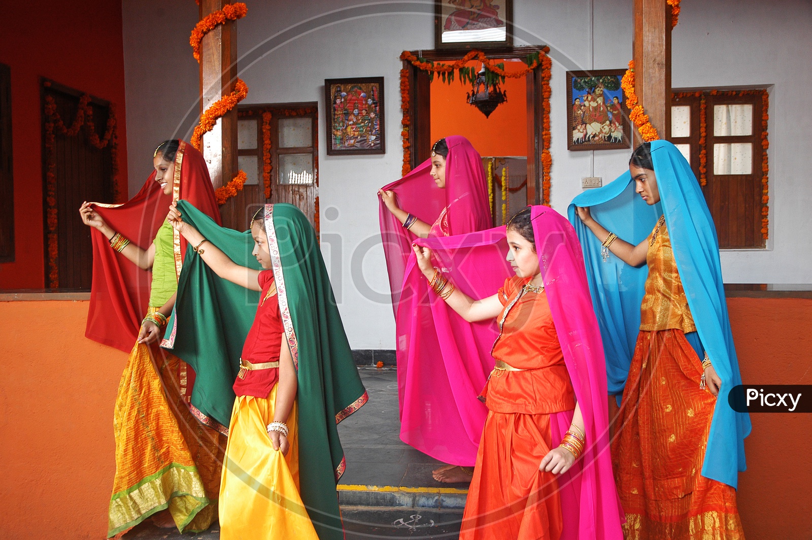 A group of girls dancing in Indian traditional wear in the house