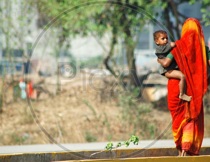 Mother carrying his child in the hot sun