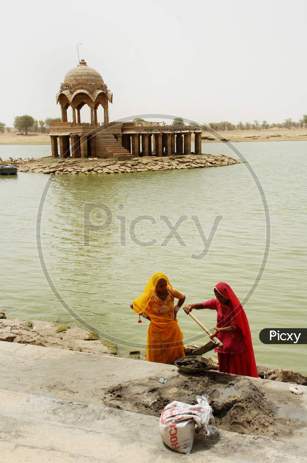 Rajasthani women taking cement using an Indian shovel