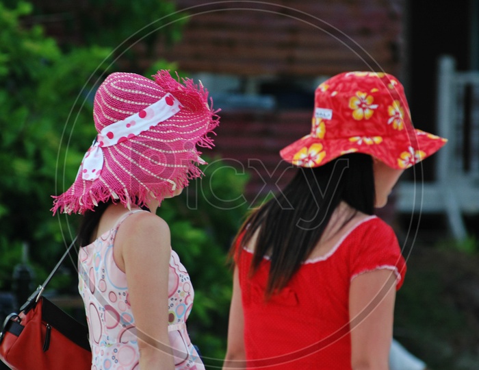 Two women wearing floral hats