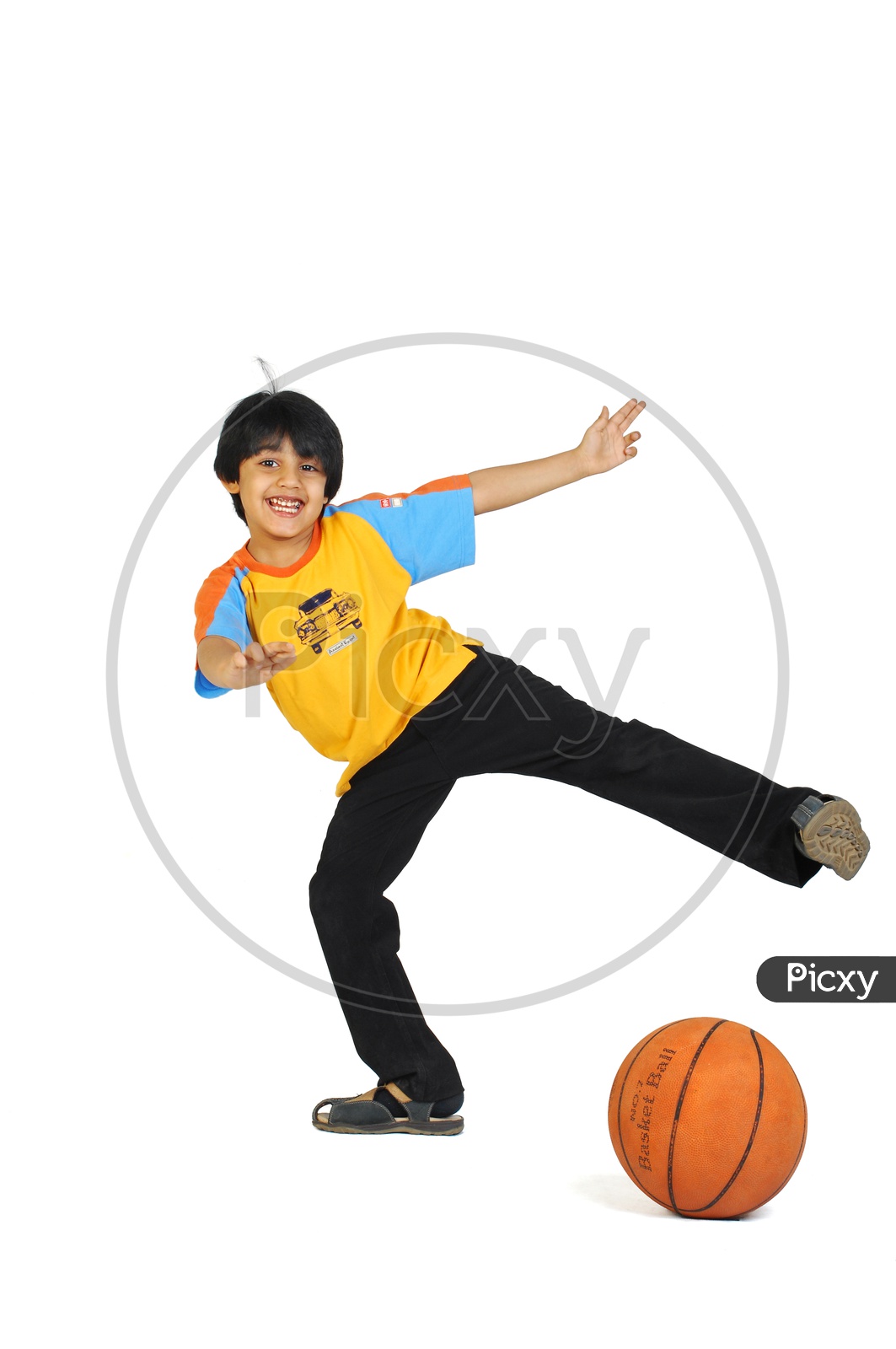 An Indian boy playing with basketball in white background
