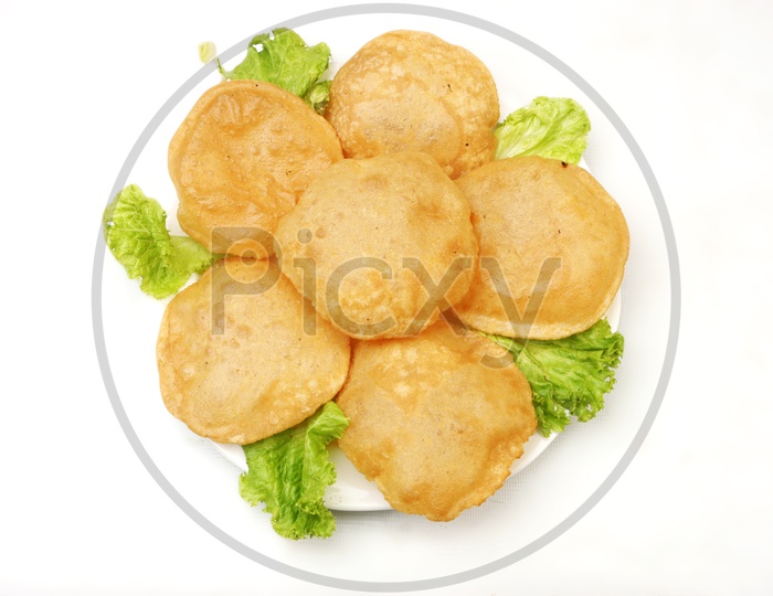 Indian breakfast Poori and lettuce in a white plate on white background