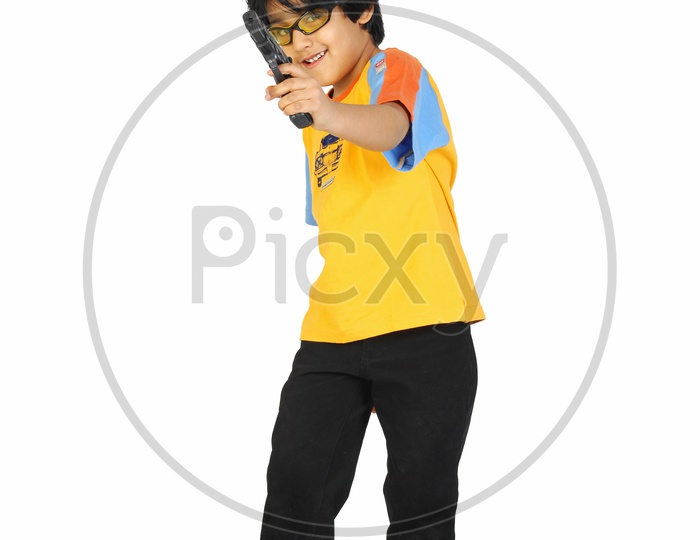 An Indian boy with specs and toy gun in hand - white background