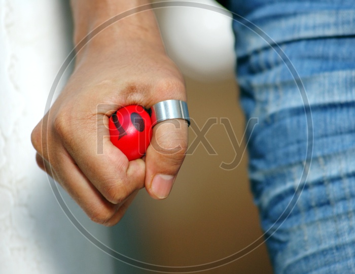 Man holding a red smiley ball