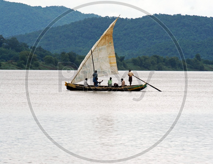 People traveling in a boat with mountains in the background