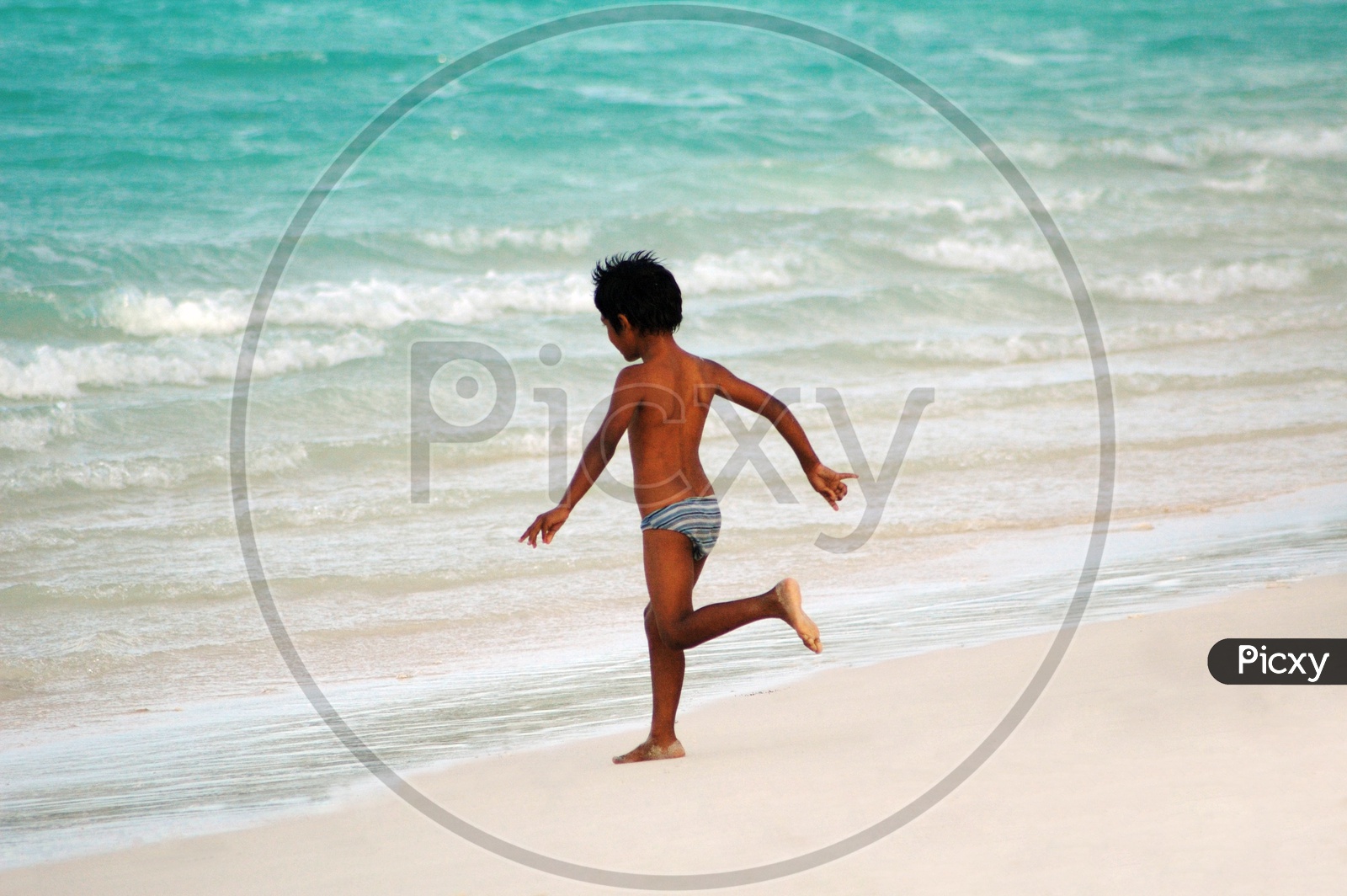 A boy running into the beach