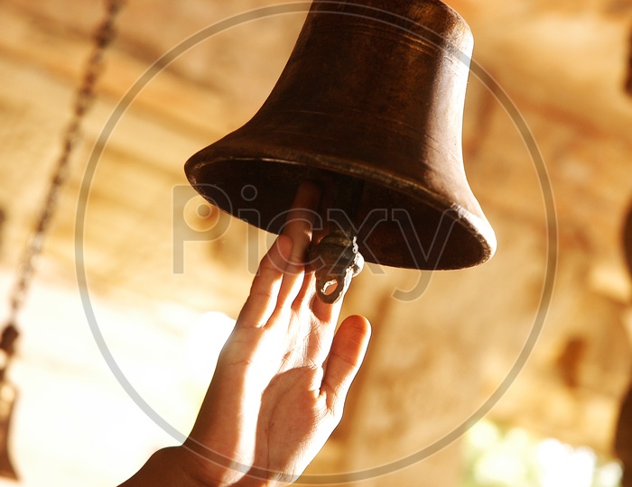 Indian woman ringing the bell at Temple