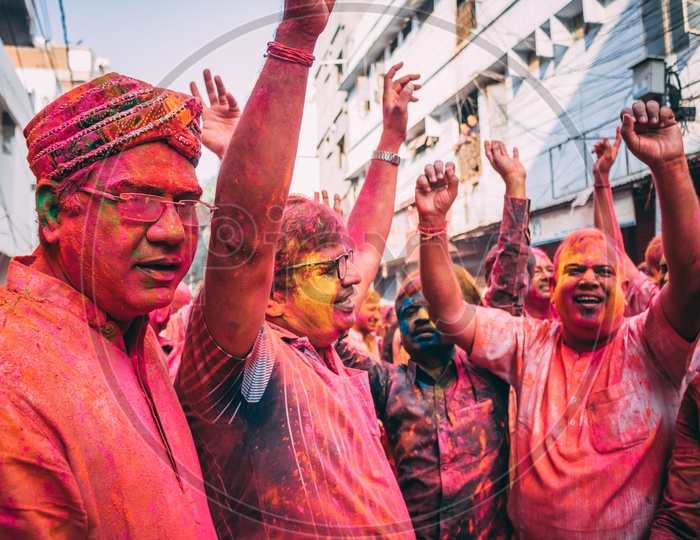 people happily dancing on the day of holi