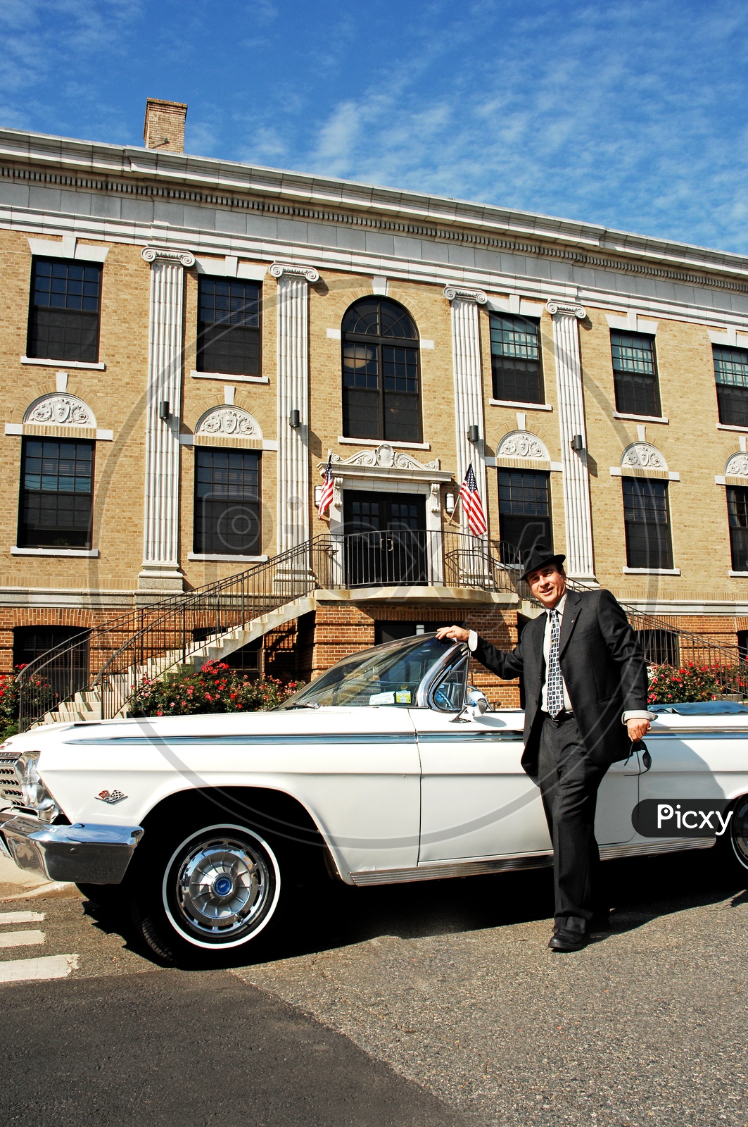 Handsome elegant man in suit posing against black luxury car Stock Photo |  Adobe Stock