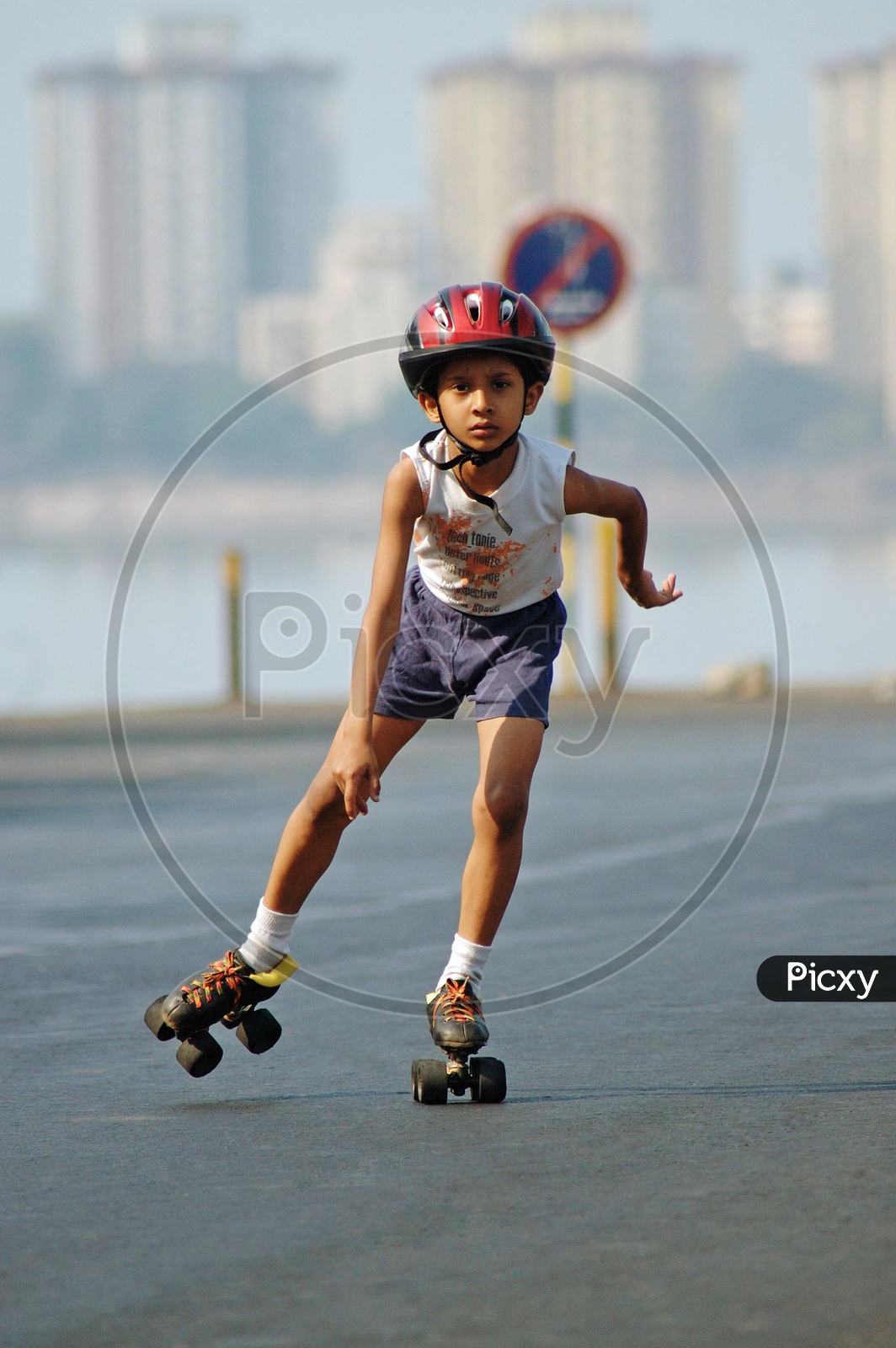 A boy skating on the road wearing a helmet