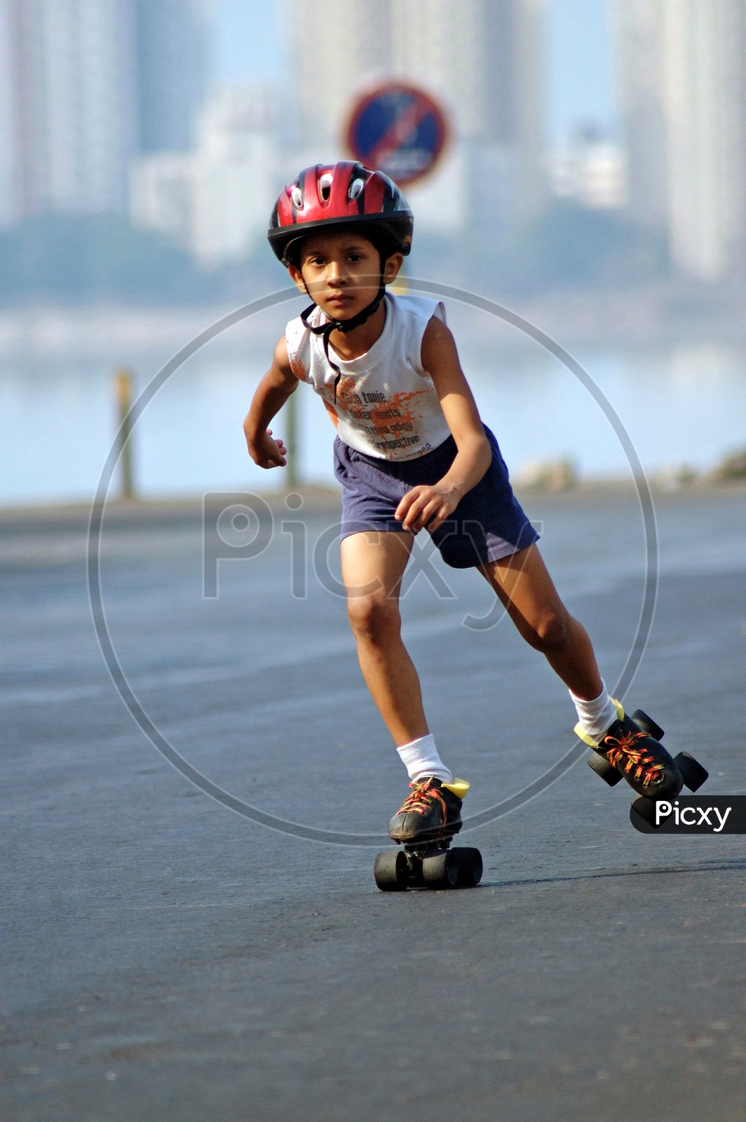 A boy skating in the road wearing a helmet