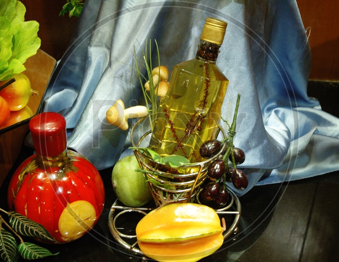Artificial fruits and a glass bottle