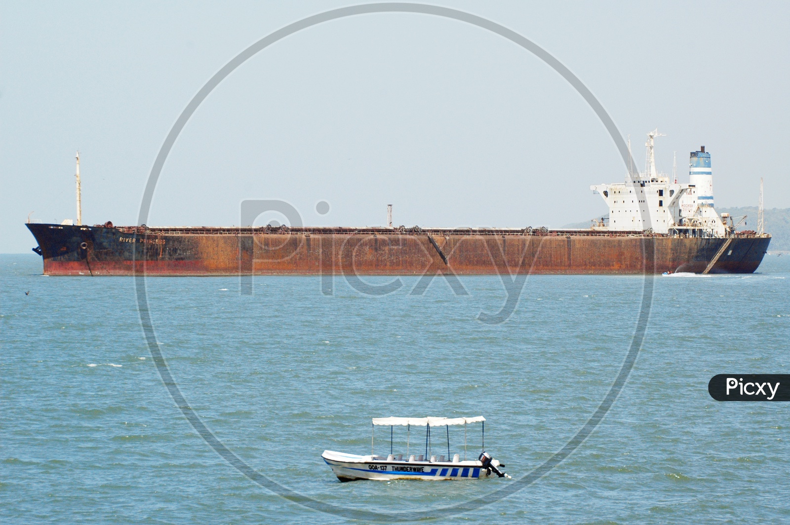 Cargo ship and a small boat in the Arabian sea
